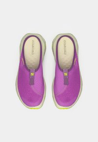 Μωβ παπούτσια τύπου slip-on με διχτυωτό πάνω μέρος, ταμπά πάτο και χαρακτηριστικά κίτρινων λεπτομερειών. Ελαφρύς σχεδιασμός, υφασμένες επιφάνειες και στρογγυλεμένο σχήμα.