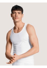 Witte geribde tanktop van rekbare stof, met een ronde halslijn en brede schouderbanden, aansluitend ontwerp dat de torso benadrukt.