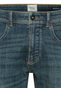 Denim-Jeans in einer mittelblauen Waschung, mit Knopfverschluss, Fünf-Taschen-Design und kontrastierenden Nähten. Normale Passform mit einer strukturierten Oberfläche.