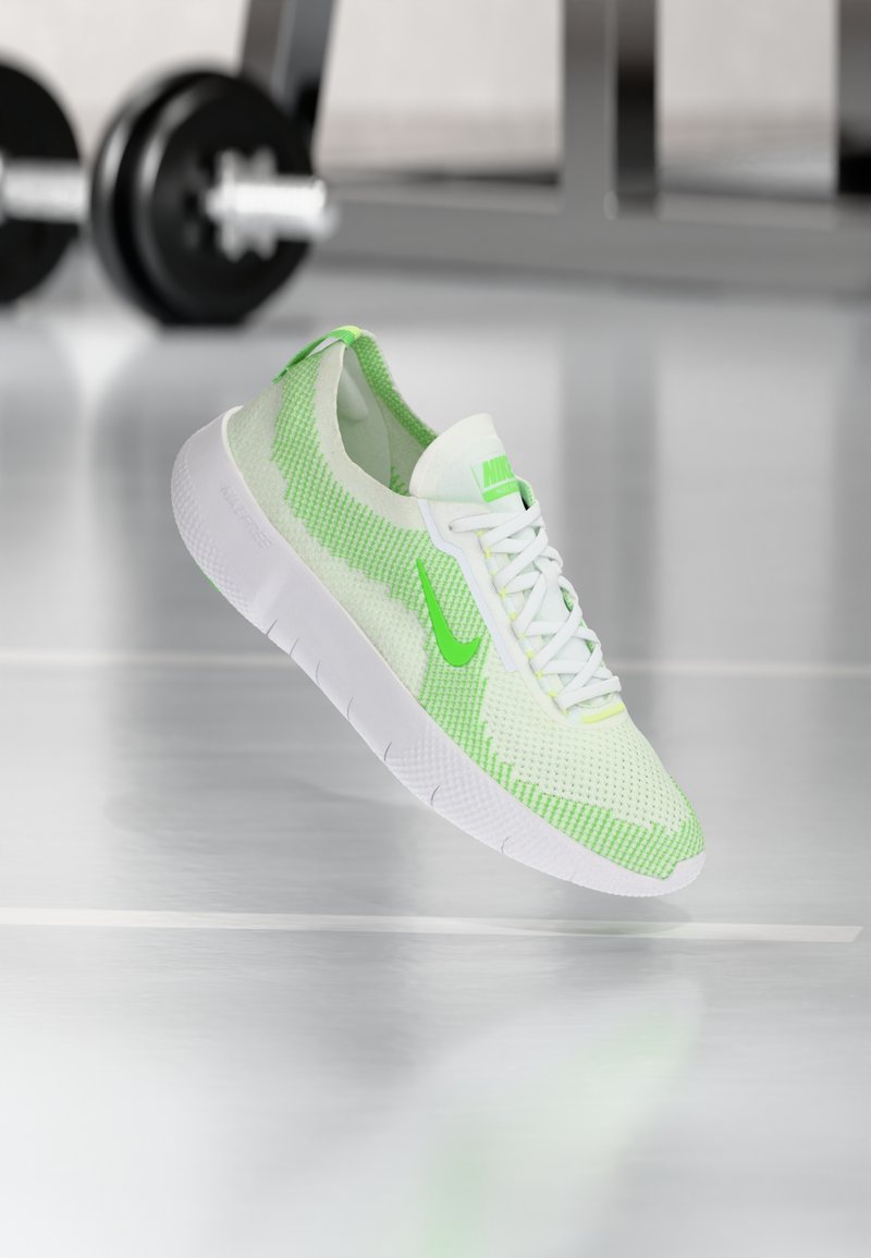 Chaussure de sport légère en mesh vert et blanc avec un motif texturé. Dispose d'une semelle épaisse blanche et de lacets blancs. Marquage Nike visible.