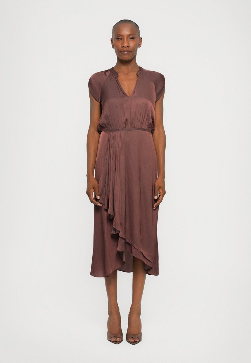 Robe marron, longueur genou, avec des manches courtes, un décolleté en V et un ourlet asymétrique. Réalisée en tissu lisse avec de délicats détails drapés.