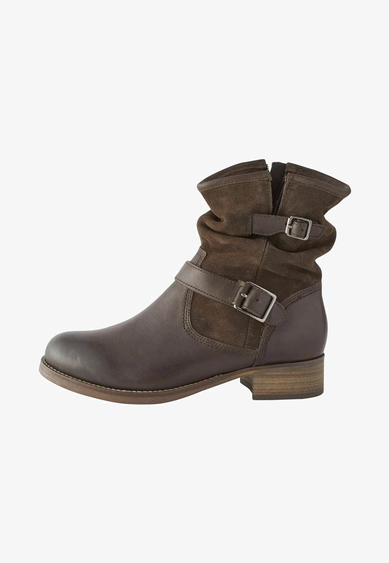 Bota de tobillo de cuero marrón y gamuza con un cuello holgado, doble hebilla lateral y un tacón bajo de madera. Textura suave y punta redondeada.