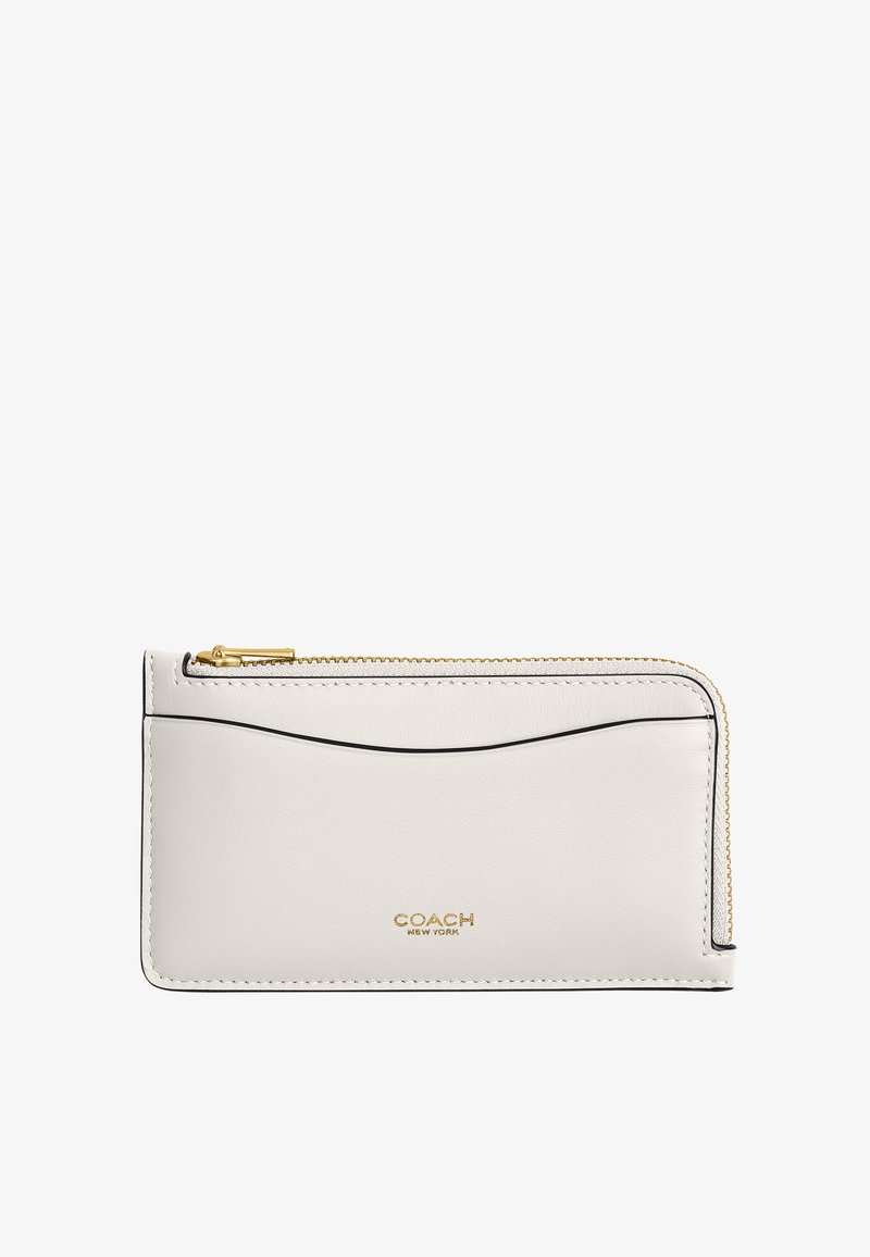 Portefeuille Coach en cuir blanc avec fermeture éclair dorée sur tout le pourtour, fente pour carte à l'avant et logo estampé en doré au centre en bas.
