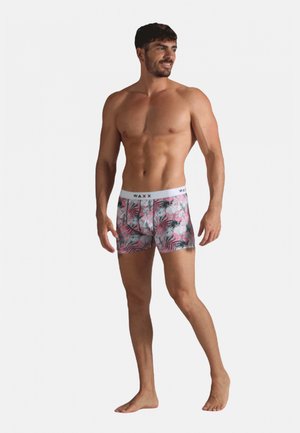 Boxers pour hommes dans un motif de feuilles tropicales rose vif et gris, en tissu extensible, avec une taille blanche arborant le logo de la marque.