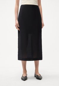 Czarna spódnica midi wykonana z lekkiego materiału, o prostym kroju, gładkiej fakturze i lekko rozszerzającym się dołem.