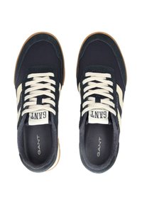 Sneakers blu navy con accenti bianchi. Realizzati in suede e tessuto, con suola in gomma, punta rotonda e lacci beige. Nome del marchio "GANT" visibile.
