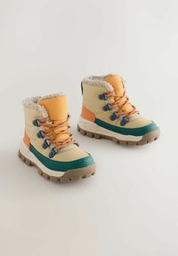 Bottes de randonnée pour enfants avec une combinaison de couleurs crème, orange et turquoise. Elles présentent une doublure moelleuse, une semelle en caoutchouc durable et des lacets contrastés.
