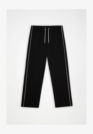 Schwarze Freizeithose mit weißen Seitenstreifen und weißem Kordelzug am elastischen Bund, flach auf weißem Hintergrund liegend.