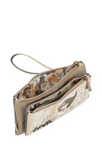 Clutch beige con estampado que cuenta con tres compartimentos con cremallera, forro floral, exterior texturizado y una correa desmontable. Presenta acentos decorativos.