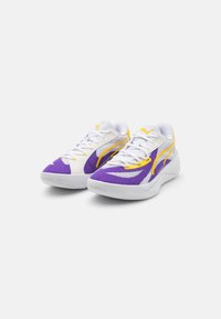 Adidași albi și mov cu accente galbene, prezentând un material texturat și o talpă din cauciuc cu un model de aderență. Șireturile sunt vizibile.