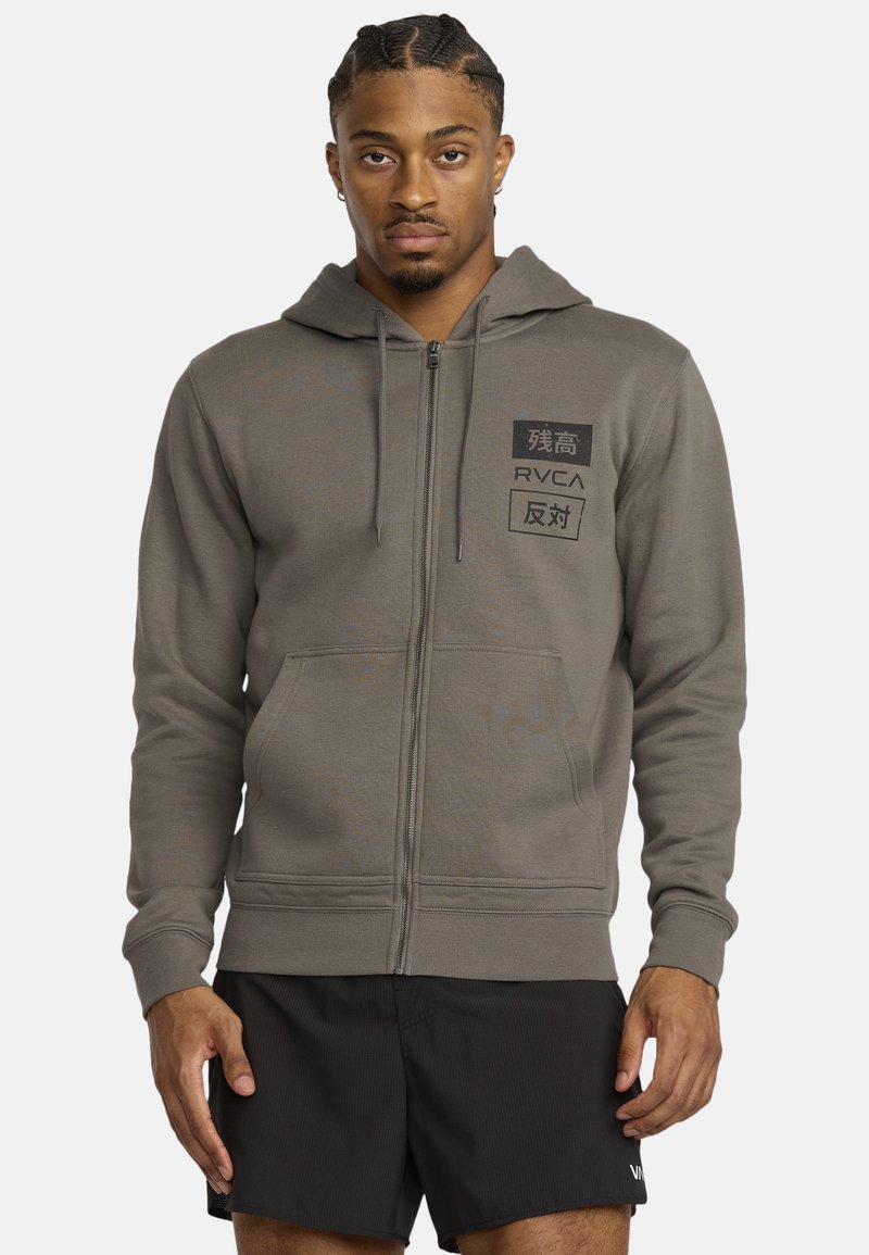 Grijze zip-up hoodie met een trekkoordcapuchon, voorzakken en zwarte logo-accenten. Gemaakt van zachte materialen en heeft een relaxte fit.