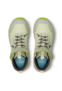 Chaussures mi-hautes imperméables vert clair avec une tige texturée, des lacets noirs et un accent vert contrastant sur le bout et la sangle.