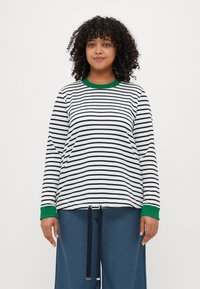 Camicia a manica lunga bianca con righe navy, dotata di colletto e polsini a coste verdi. Progettata con un orlo con cordoncino per una vestibilità regolabile.
