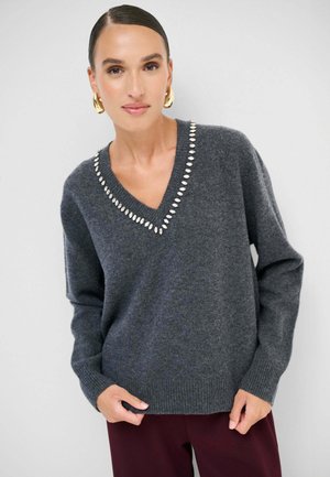 Maglione grigio in lana con scollatura a V, impreziosito da accenti argentati lungo il collo. Caratterizzato da maniche lunghe e polsini a costine.