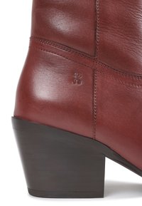 Brown leather ankle boot with angled wooden block heel and stitched detailing on the side.