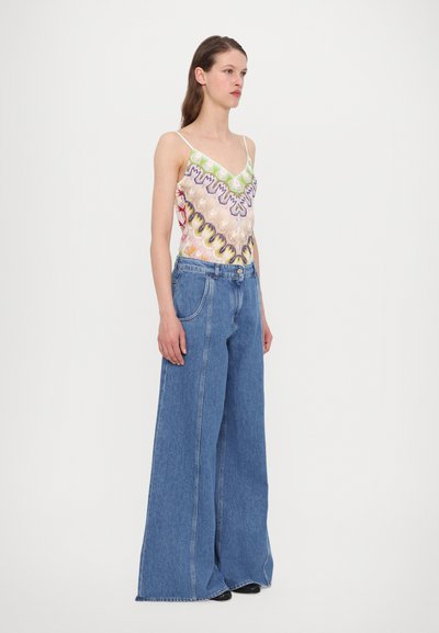 Colorful patterned tank top with thin straps paired with wide-leg denim jeans. The jeans are light blue with a high waist and visible stitching.