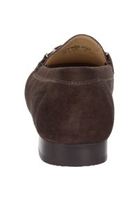 Braune Wildlederschuhe mit abgerundetem Hinterteil, niedrigem Absatz und sichtbaren Nähdetails. Innen ausgestattet mit beigefarbenem Futter und geprägtem Branding.