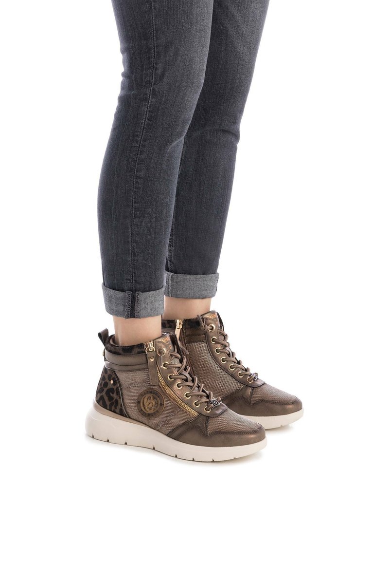 Zapatillas altas de bronce metálico con cordones en la parte delantera, cremallera lateral y acento de estampado de leopardo en el talón. Tejido texturizado y suela acolchada.