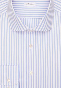 Niebieska i biała w pionowe paski koszula na guziki z wyraźnym kołnierzykiem i kieszonką na piersi, starannie złożona.