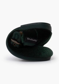 Pantofole verdi con tomaia in tessuto morbido, suola in gomma e forma curvata. Presentano un dettaglio con fibbia e un'etichetta visibile di lato.