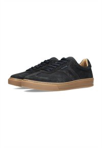 Zapatillas de ante negro con paneles texturizados, presentan cordones redondos y una suela de goma para mayor agarre. Diseño minimalista con acentos sutiles.