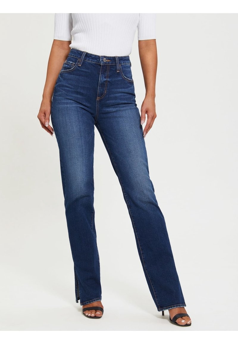 Vaqueros de denim de tiro alto en un tono azul oscuro, con un diseño de pierna recta, que cuentan con bolsillos frontales y una ligera abertura en el dobladillo para un detalle adicional.