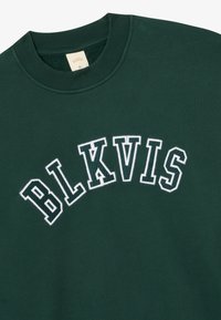 Dunkelgrüner Rundhalsausschnitt-Pullover mit weißen gestickten "BLKVIS" Buchstaben, die bogenförmig über die Brust verlaufen, und einem Größenetikett XL im Kragen.