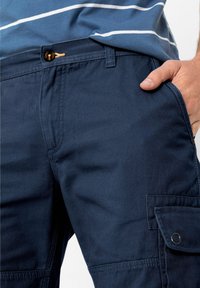 Pantaloni cargo blu navy con una texture liscia, dotati di tasca frontale, chiusura con bottone e tasca laterale cargo con patta.