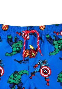Swim trunks featuring a blue background with colorful superhero graphics, a red drawstring, and a pattern of iconic character poses.