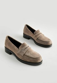 Mocassini in suede marrone con tacco nero basso, caratterizzati da un dettaglio a fascia tipo penny e una finitura liscia e strutturata.