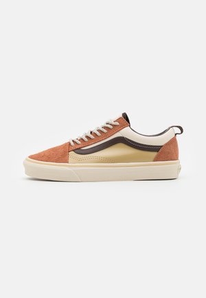 Zapatilla de deporte con cordones que presenta un upper de ante en tonos marrón claro y naranja, acentos de cuero beige y una suela de goma beige. Cordones planos y una pestaña de agarre en la parte trasera.