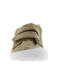 Zapato deslizante de tela color beige con bandas elásticas sobre el empeine, suela de goma blanca y superficie texturizada. Diseño compacto y de punta redondeada.