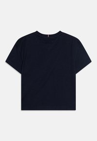 T-shirt cropped bleu marine en coton doux, avec des manches courtes et un col rond, présentant un petit accent rouge sur la couture arrière.