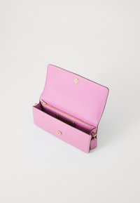 Pink leather wallet with a smooth texture, gold hardware, and a zippered pocket inside. Open design showcasing one main compartment.
