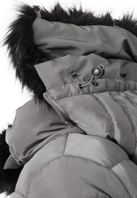 Grey padded jacket featuring a detachable hood with black fur trim, adjustable drawstring, and visible zipper detailing. Smooth, glossy texture.