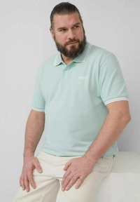 Hellblaues Poloshirt mit Kragen, versehen mit weißen Akzenten an den Ärmeln und einem Logo auf der Brust; aus gestricktem Stoff.