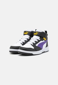 Høye sneakers med svart syntetisk overdel, hvit perforert tåboks, lilla side stripe og gul logo, med snøring og justerbar stropp.