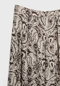 Beige en donkerbruin paisleypatroon stof met bloemaccenten, geplooid ontwerp en tailleband zichtbaar op het kledingstuk.