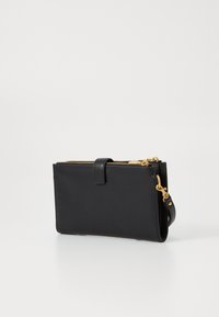 Black leather wallet with two zippered compartments, gold hardware accents, and a side strap attachment. Smooth texture and minimalistic design.