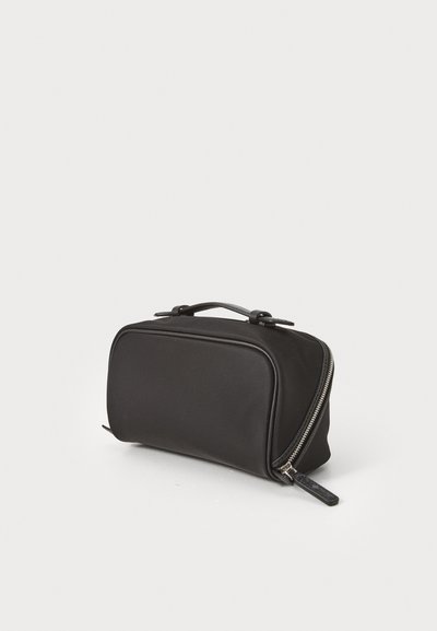 Bolsa de cosméticos preta com formato retangular, textura lisa, fecho com zíper e uma alça na parte superior para facilitar o transporte.