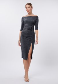 Off-the-shoulder, fitted dress in dark metallic fabric. Features three-quarter sleeves, side slit, and gathered detailing on the front.