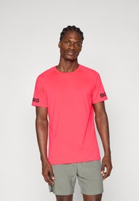 Red athletic t-shirt with short sleeves, crew neck, and black "BORG" logo on the left sleeve; made of lightweight, breathable fabric.