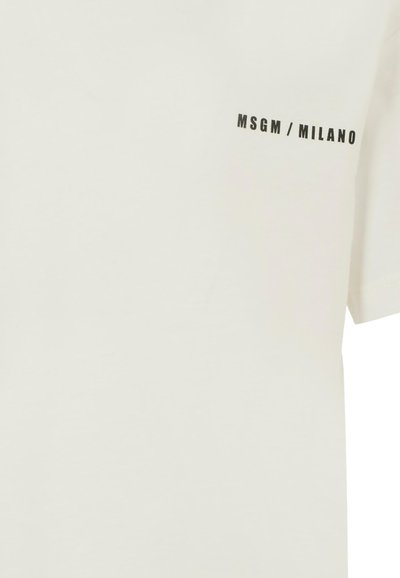 T-shirt in cotone, colore avorio, maniche corte, con la scritta nera "MSGM / MILANO" sul lato sinistro superiore. Texture liscia, vestibilità casual.