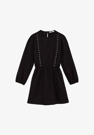 Crna haljina dugih rukava s nakupljenim strukom, okruglim izrezom, dugmadi na leđima i dva vertikalna reda srebrnih zakovica na prednjem dijelu.