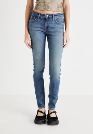 Jean skinny en denim bleu moyen, avec une taille mi-haute, un design à cinq poches, des coutures discrètes et une finition légèrement délavée.