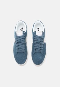 Blue suede sneakers with white side accents and matching laces. Round toe design and padded collar for comfort; textured surface visible.
