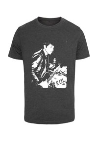 Sort T-shirt med en hvid grafik af en musiker, der spiller guitar, med en trommeslager i baggrunden. Stoffet ser blødt og åndbart ud.