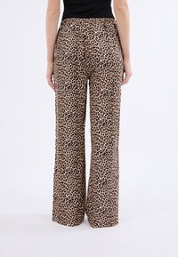 Kalhoty ve vzoru leopardí kůže, s širokými nohavicemi a elastickým pasem, v odstínech hnědé a béžové. Měkká, lehká tkanina zvyšuje pohodlí.