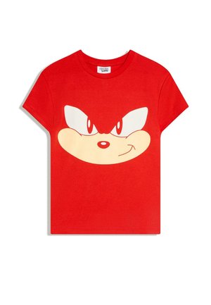 Maglietta rossa a maniche corte con un grande volto stilizzato di Sonic the Hedgehog, con occhi determinati e una bocca accennata a un sorriso sul davanti.