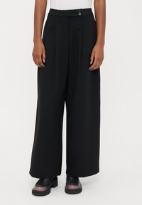 Μαύρο παντελόνι φαρδιάς γραμμής με ψηλή μέση, διαθέτει δύο πιέτες εμπρός, πλαϊνές τσέπες και δύο κουμπιά στη μέση. Λεία υφή υφάσματος.